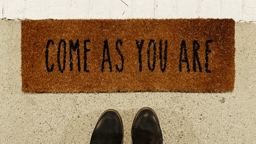 Picture of a doormat that says, "Come as you are."